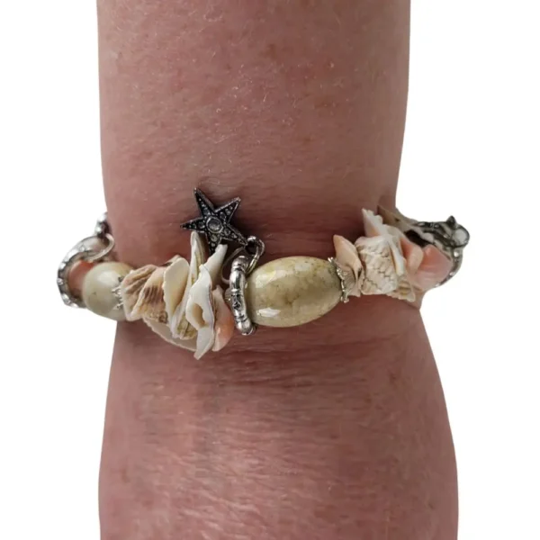 Armbånd med skaller og pynteelementer vist på en arm